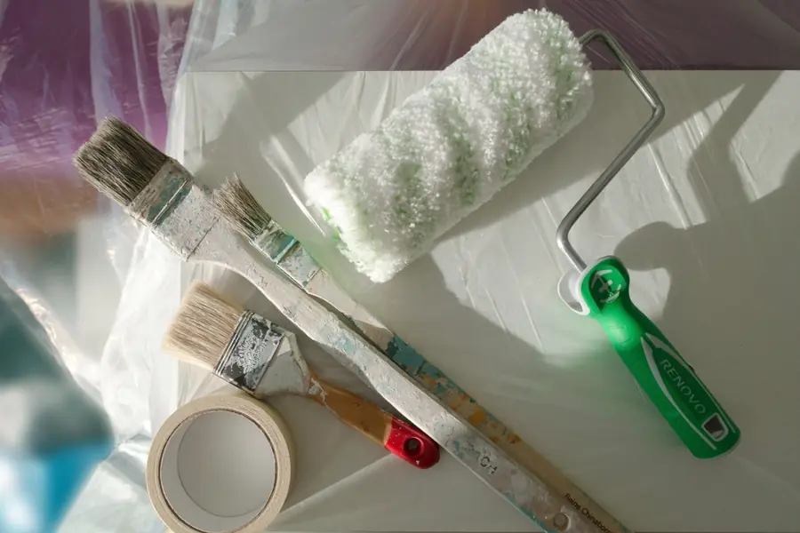 Brushes, roller and masking tape on dust sheets
